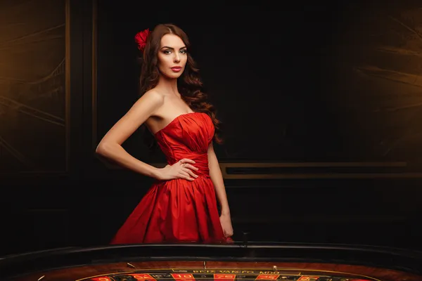 A young woman relaxing with her phone while dynamic casino elements float around her, illustrating the smooth mobile experience offered by the 2J777 app.
